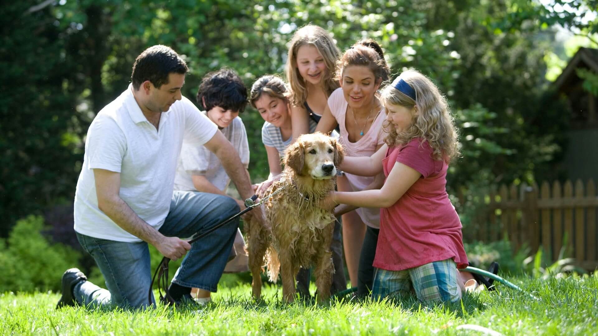 Familia bañando a un perro.